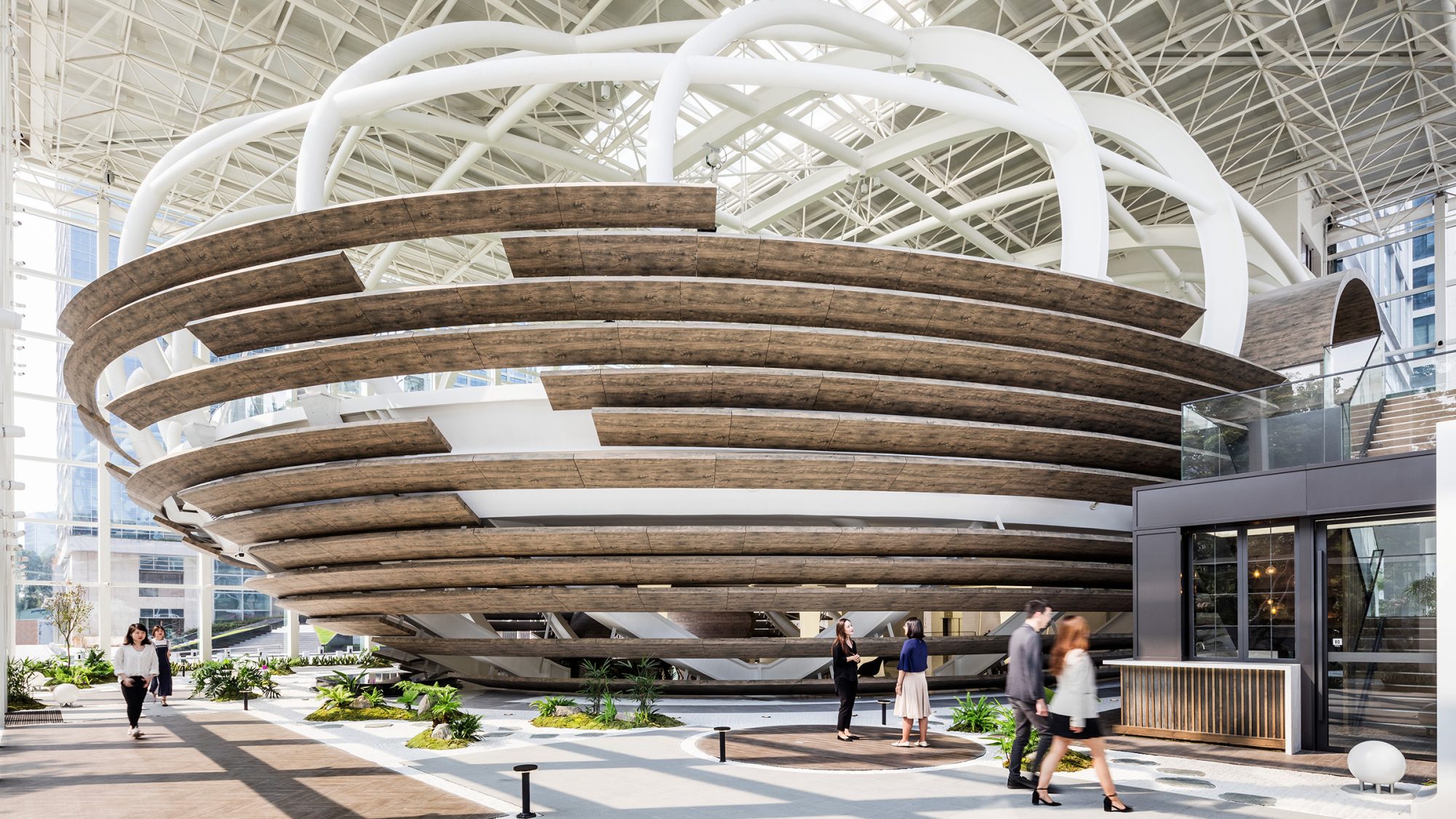 people walking around and talking in front of egg structure