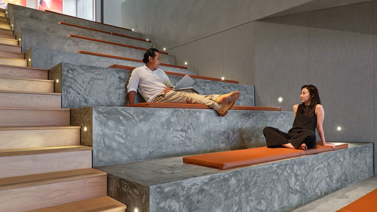 man and woman sitting on tiered stairs and collaborating