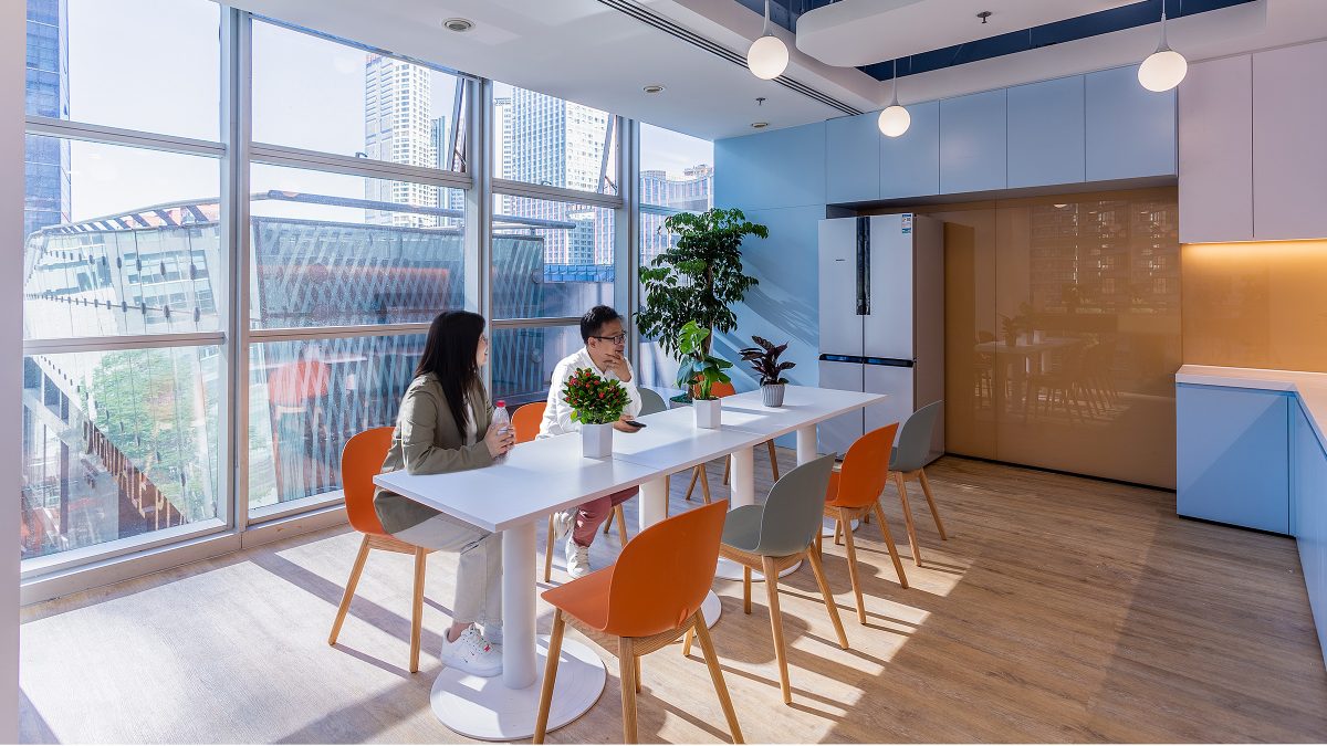 Colleagues sitting at table in kitchen area