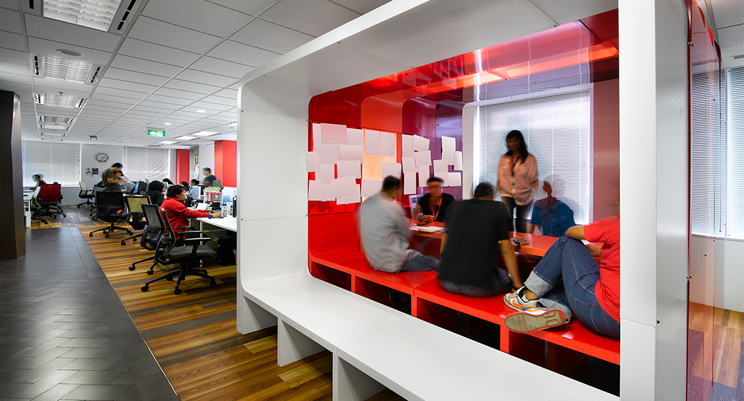 people collaborating in meeting room cubicle and people working in open plan area