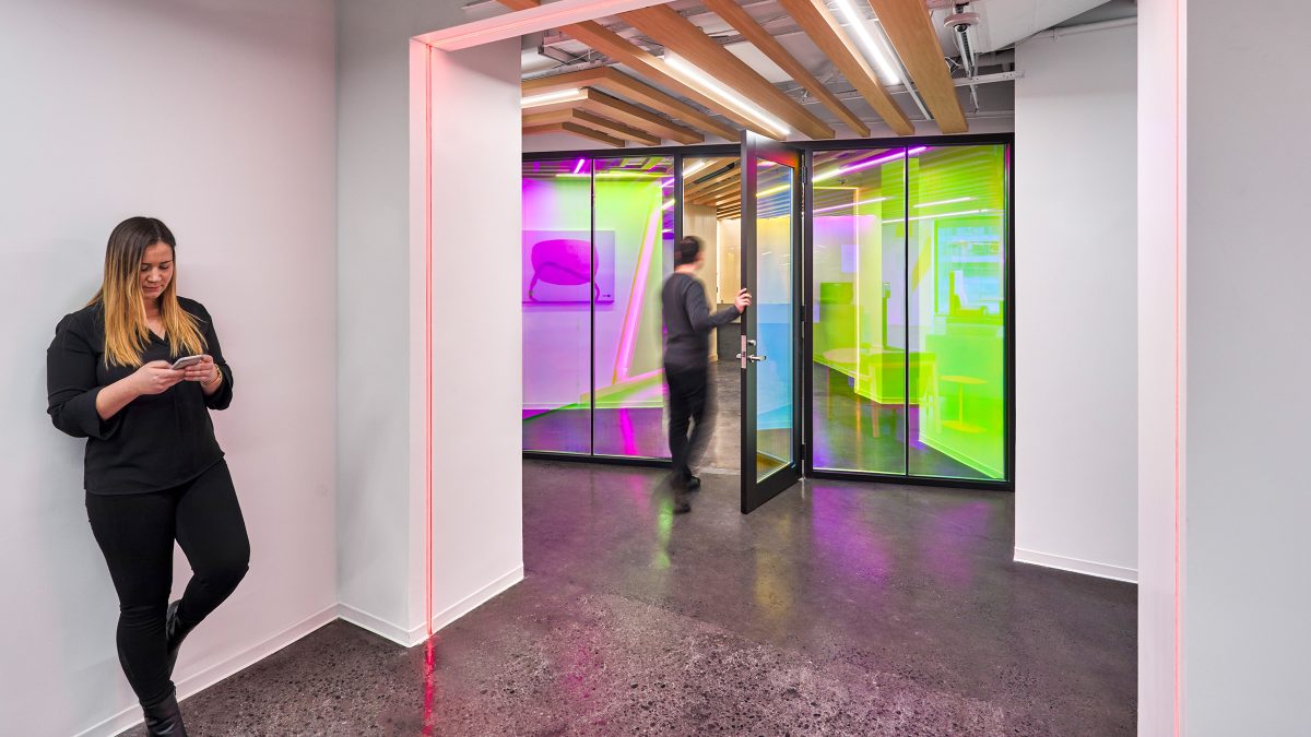 woman on phone in hallway and man walking