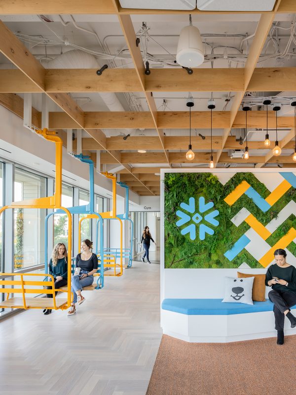 Signature brand colours and symbols are used heavily to make memorable first impressions, along with playful elements such as repurposed ski lift chairs that swing.