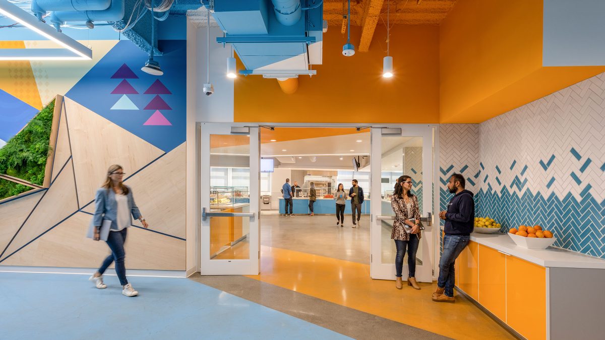 Entry point to the full canteen-style kitchen at Snowflake’s headquarters featuring colourful on-brand graphics.